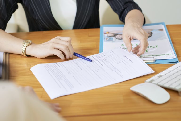 Insurance agent explaining woman what to write in contract